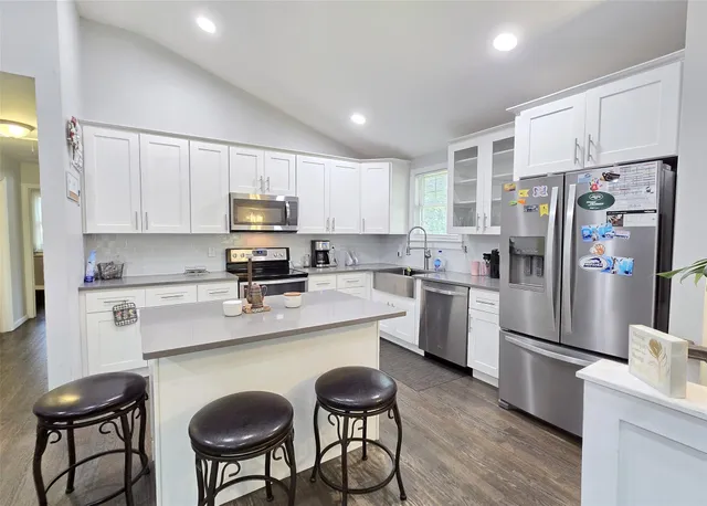 a kitchen with stainless steel appliances a refrigerator stove microwave and cabinets