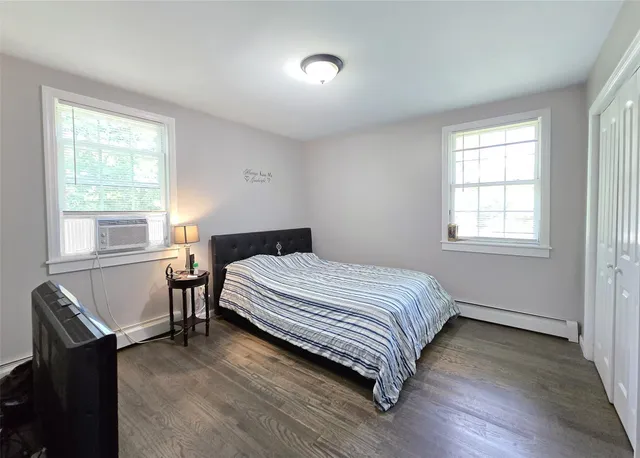 a bedroom with a bed and window with chair