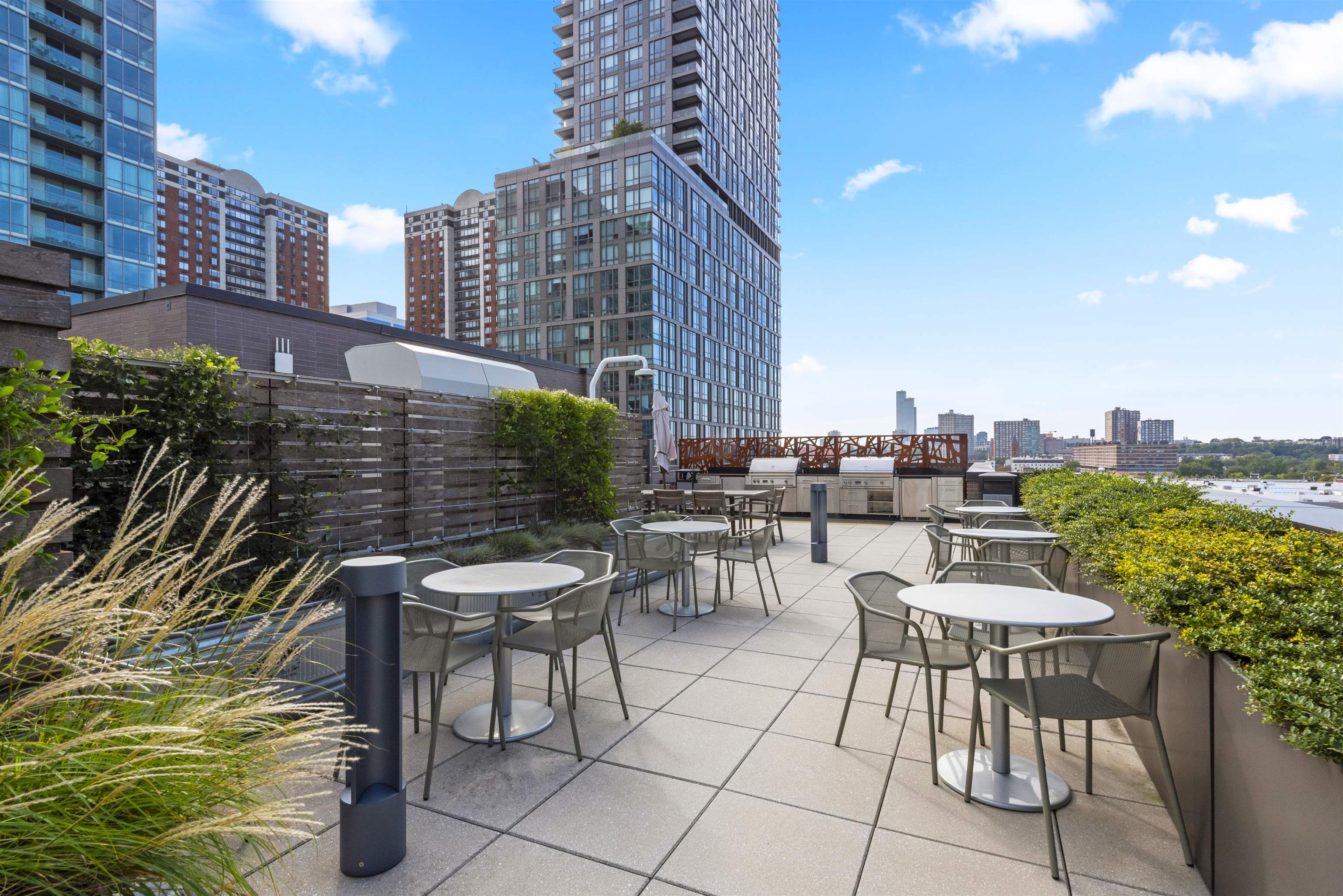2 Shore Lane, Unit 404 Jersey City, NJ 07310 - Photo 23 of 34 a view of a patio with a table and chairs and potted plants