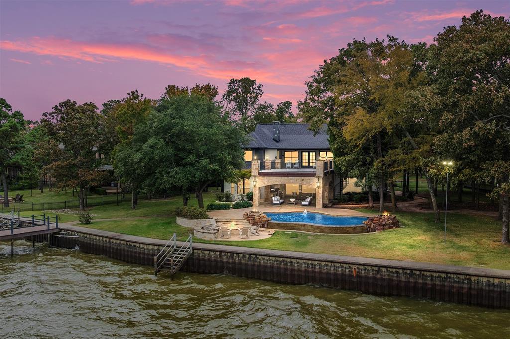a view of a swimming pool with a bench and trees around