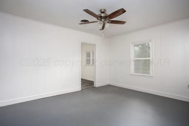 an empty room with a window and a fan