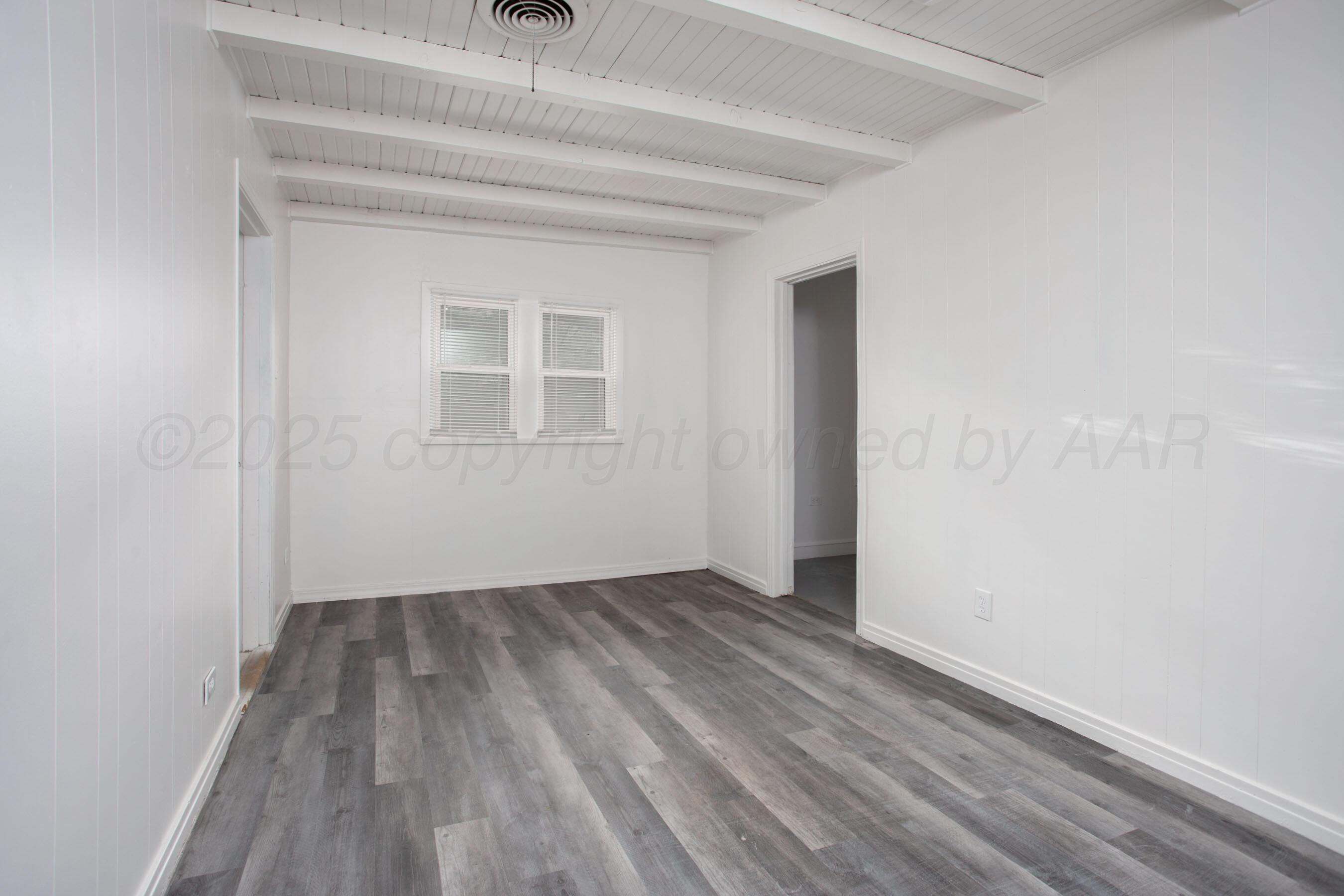 826 Sunset Terrace Amarillo, TX 79106 - Photo 22 of 28 a view of an empty room with wooden floor and a window