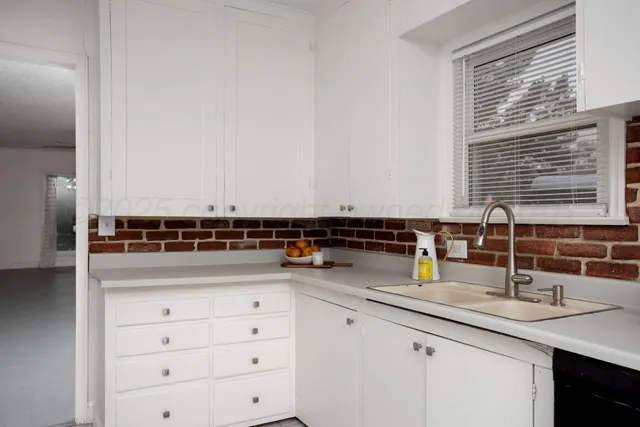 a kitchen with cabinets appliances a sink and a window