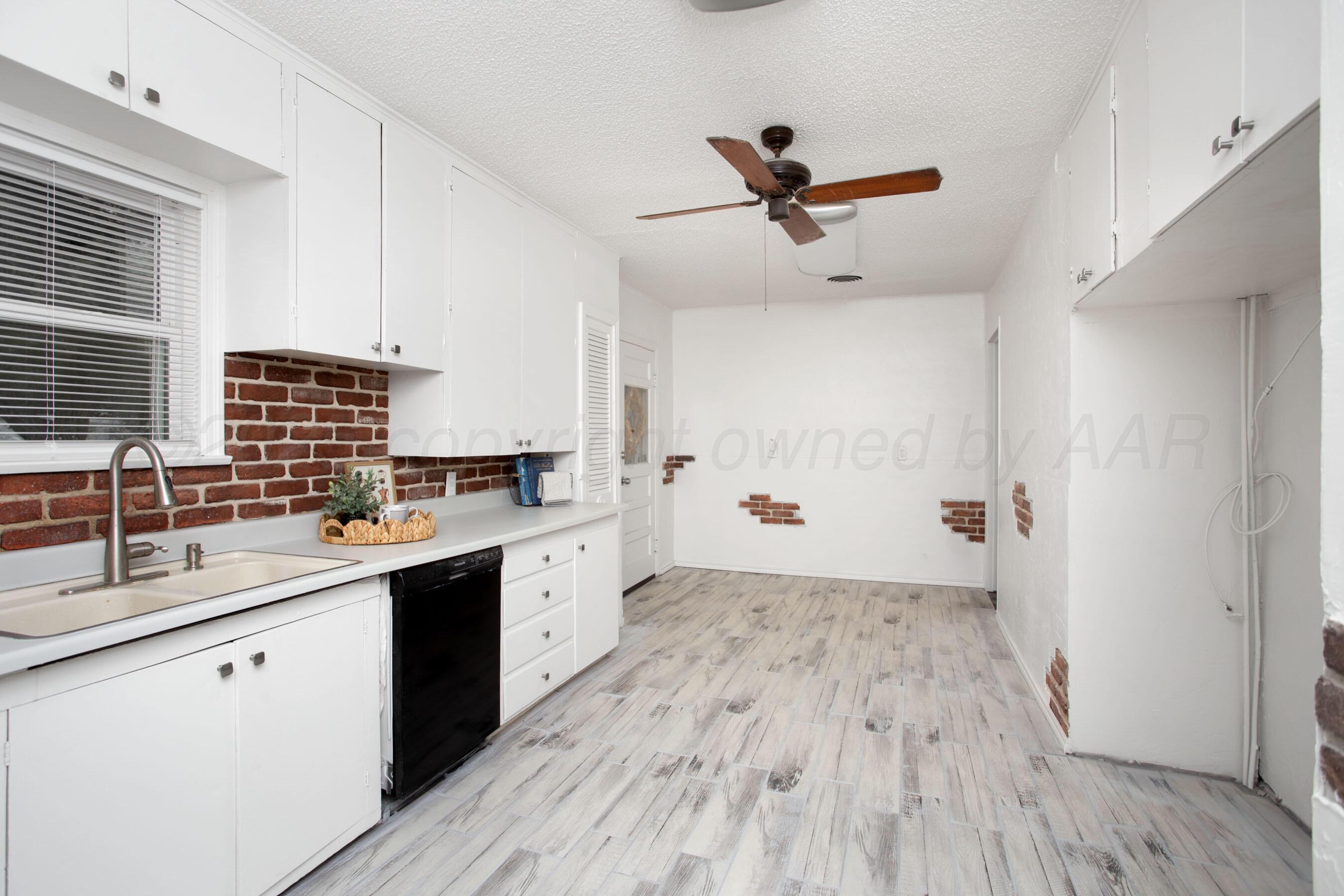 826 Sunset Terrace Amarillo, TX 79106 - Photo 9 of 28 a kitchen with wooden floors and white walls