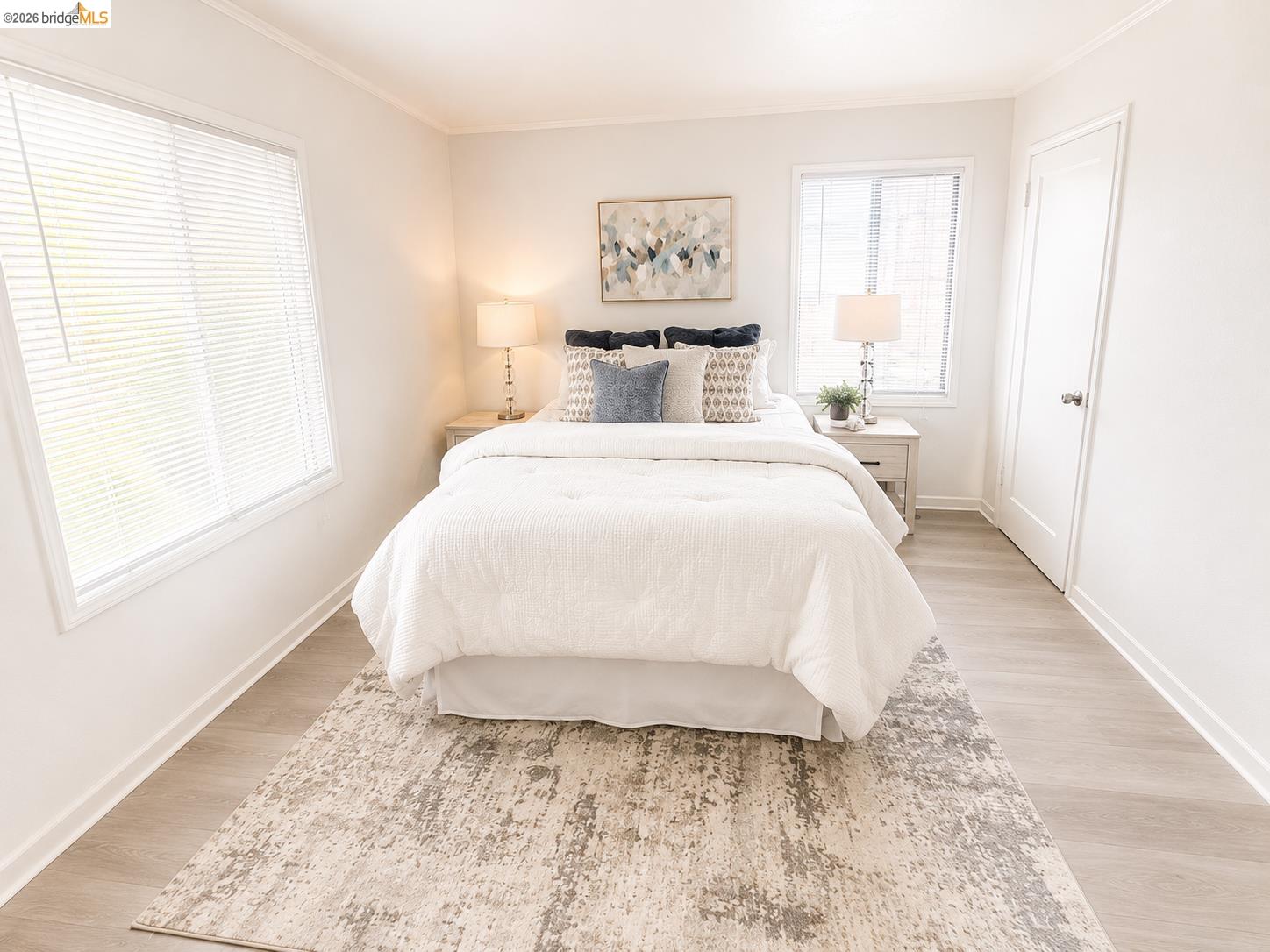 810 Pierce Street Albany, CA 94706 - Photo 8 of 25 Light-filled room featuring two windows with horizontal blinds, wood-finish flooring, white baseboards, and crown molding