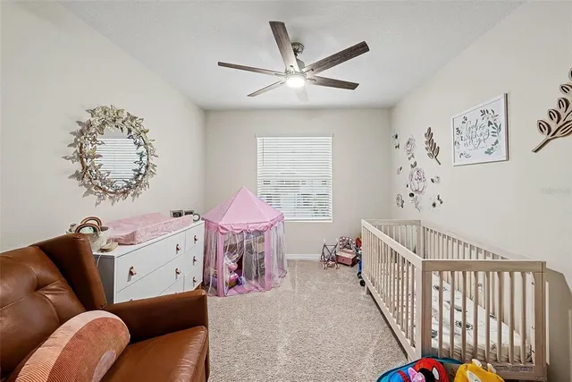 a bedroom with furniture and a chandelier fan