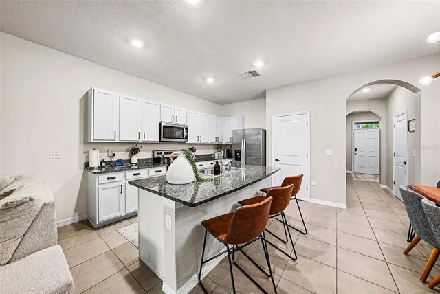 a kitchen with stainless steel appliances granite countertop a sink stove and microwave