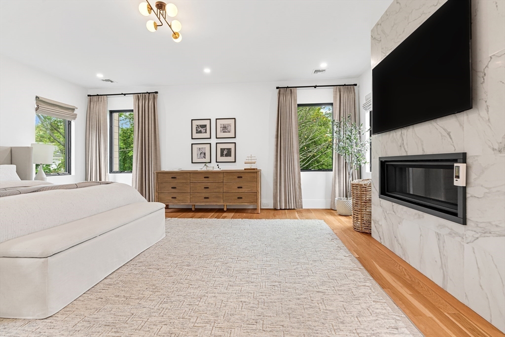 26 Chinian Path Newton, MA 02459 - Photo 14 of 29 a spacious bedroom with a large bed and a flat screen tv
