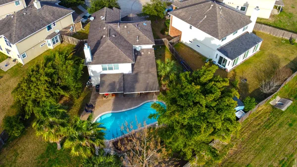an aerial view of residential houses with outdoor space and trees all around