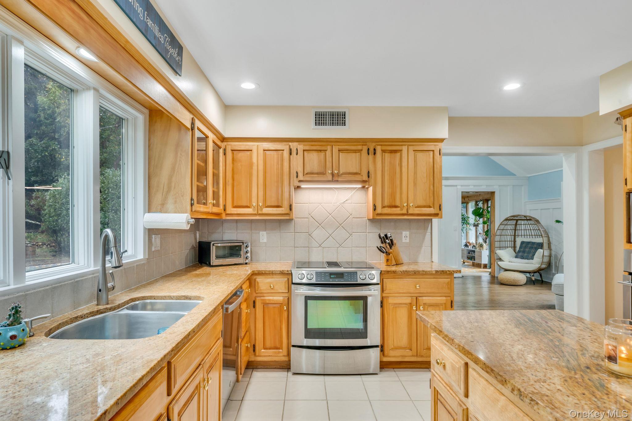 27 Tower Hill Road Shoreham, NY 11786 - Photo 11 of 49 a kitchen with granite countertop a sink and a stove top oven