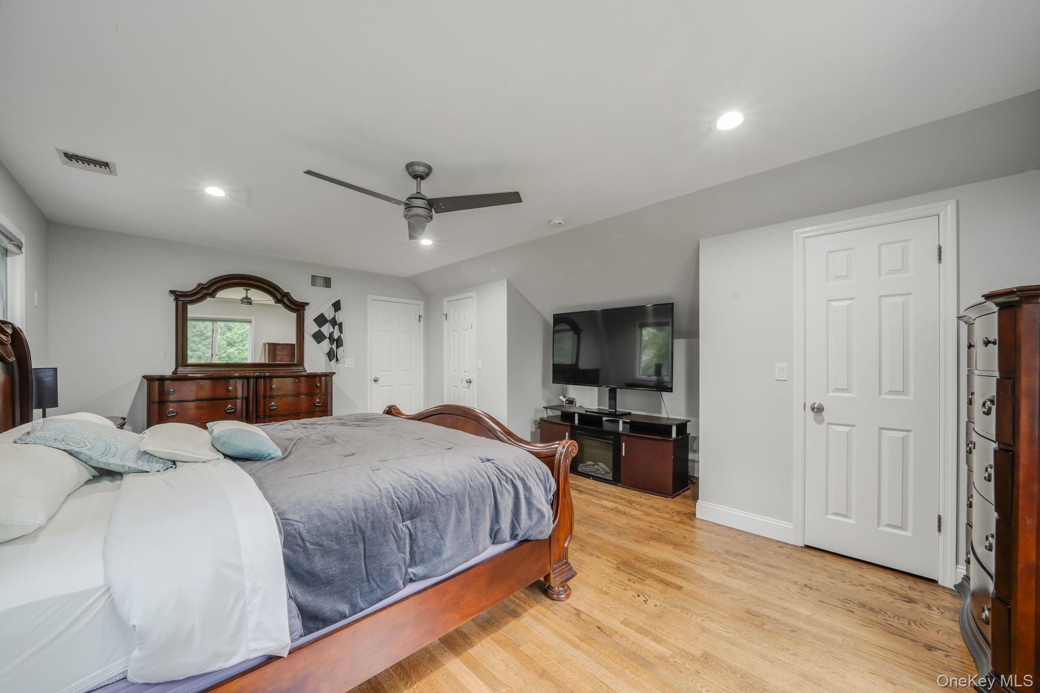 27 Tower Hill Road Shoreham, NY 11786 - Photo 31 of 49 a bedroom with a bed a dresser and flat screen tv