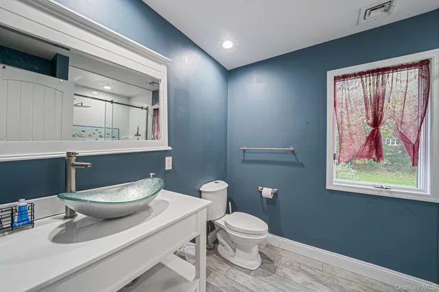 a bathroom with a toilet a sink and mirror