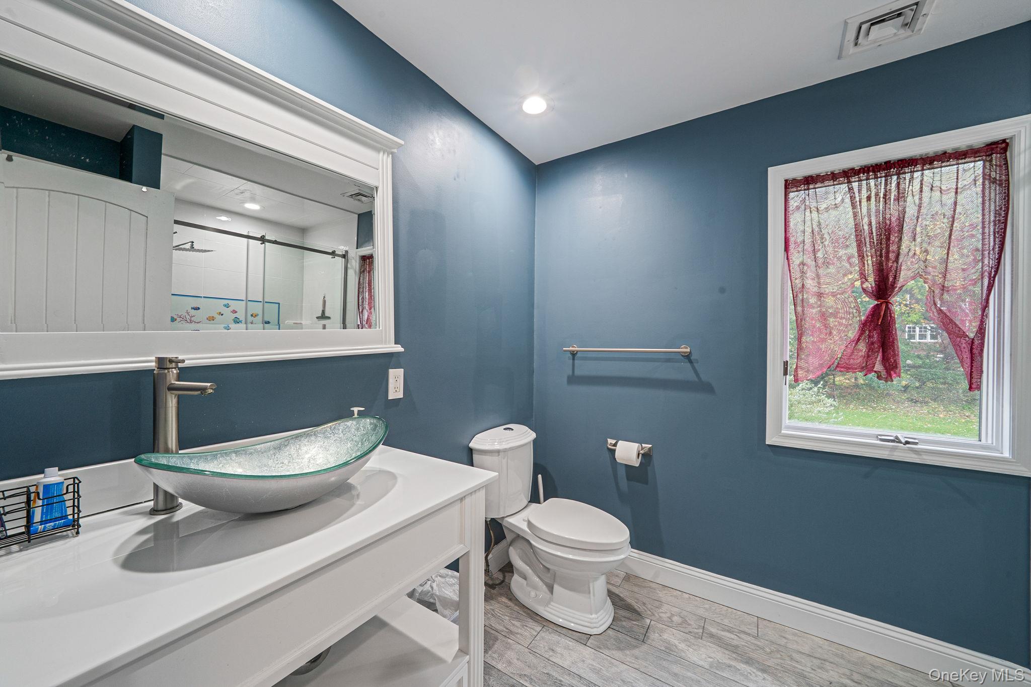 27 Tower Hill Road Shoreham, NY 11786 - Photo 35 of 49 a bathroom with a toilet a sink and mirror