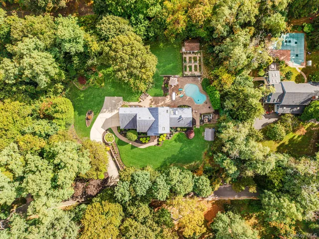 an aerial view of a house with swimming pool and outdoor seating