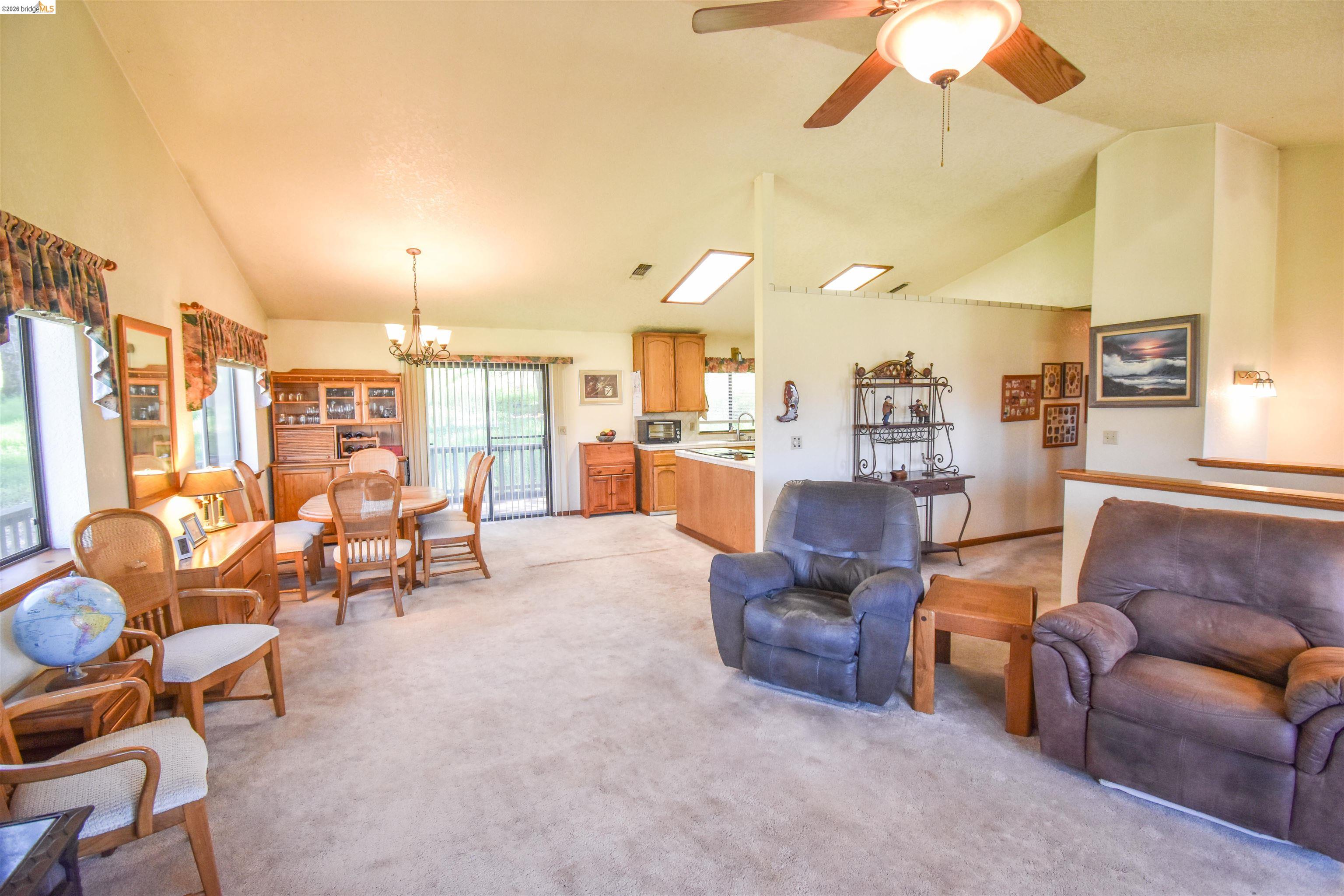 15170 Potato Ranch Road Sonora, CA 95370 - Photo 13 of 49 Living room featuring lofted ceiling, a chandelier, a ceiling fan, and light colored carpet