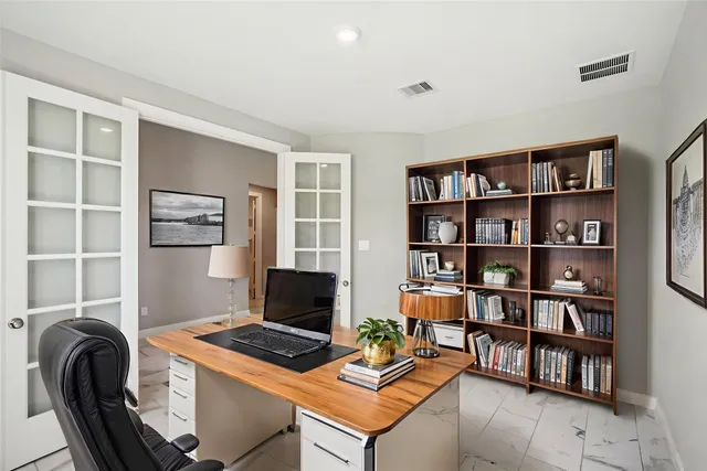 a view of a workspace with furniture and a bookshelf