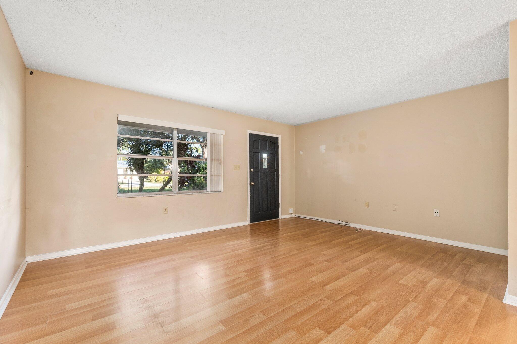 5901 Sunset Boulevard Fort Pierce, FL 34982 - Photo 6 of 26 an empty room with wooden floor and windows