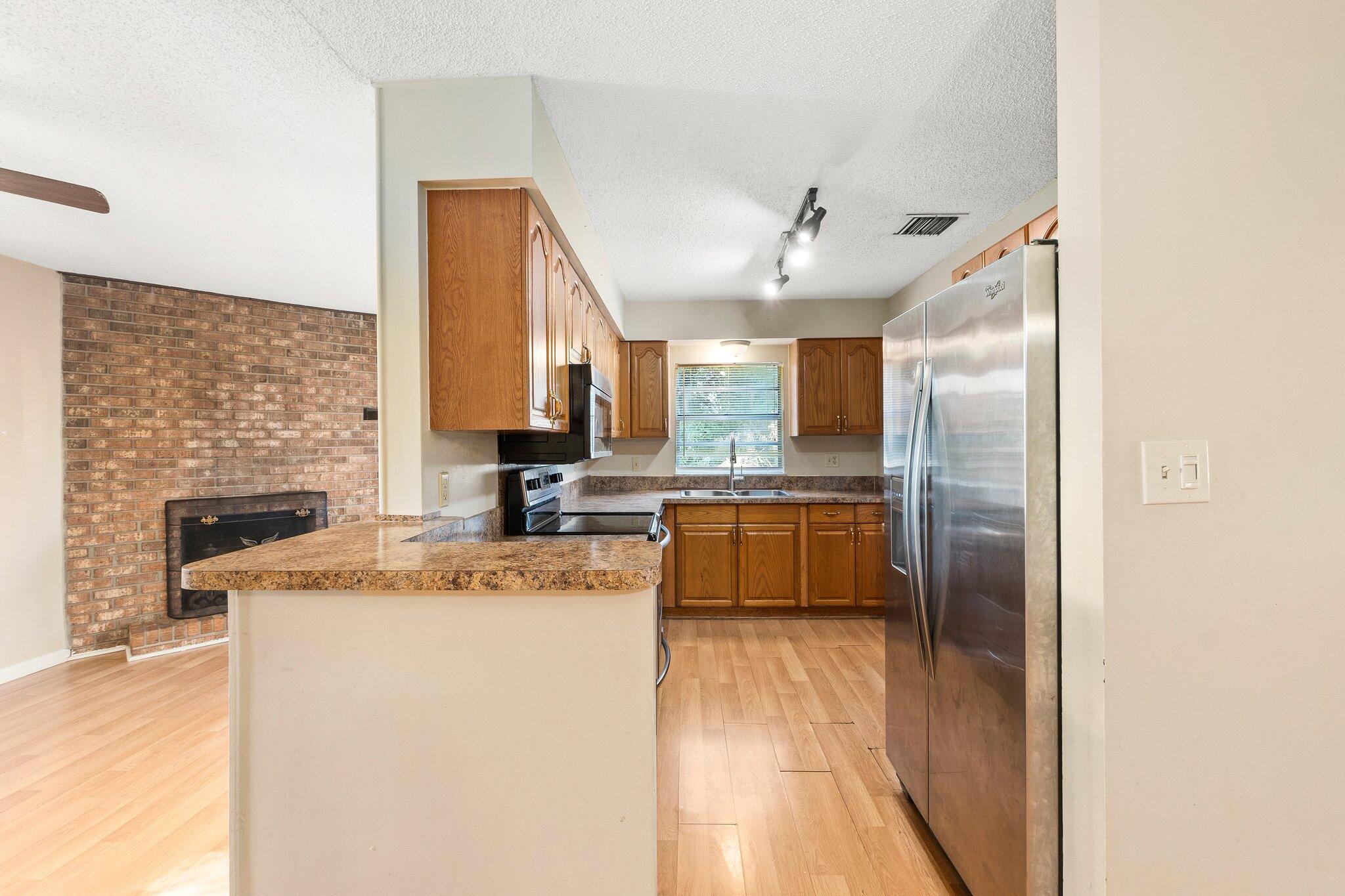 5901 Sunset Boulevard Fort Pierce, FL 34982 - Photo 9 of 26 a kitchen with stainless steel appliances granite countertop a sink a stove and a refrigerator