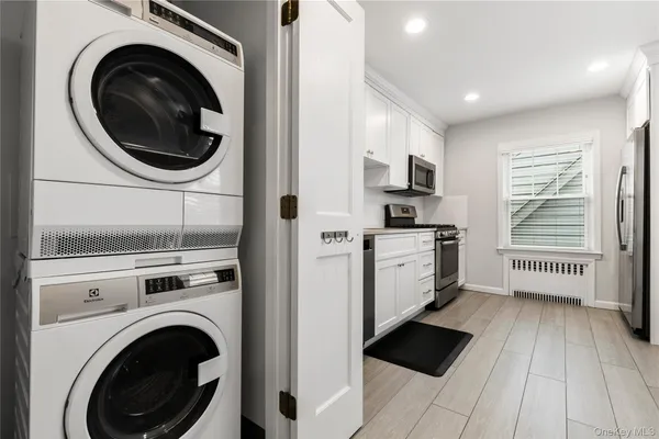 a kitchen with cabinets stainless steel appliances and a window