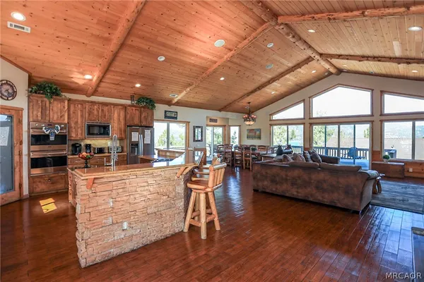 a dining table with chairs and kitchen view