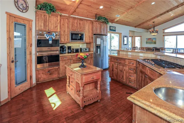 a kitchen with a appliances wooden floor dining table and chairs