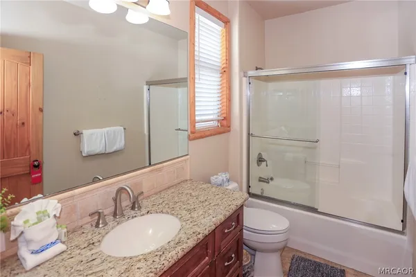 a bathroom with a granite countertop double vanity sink and a mirror