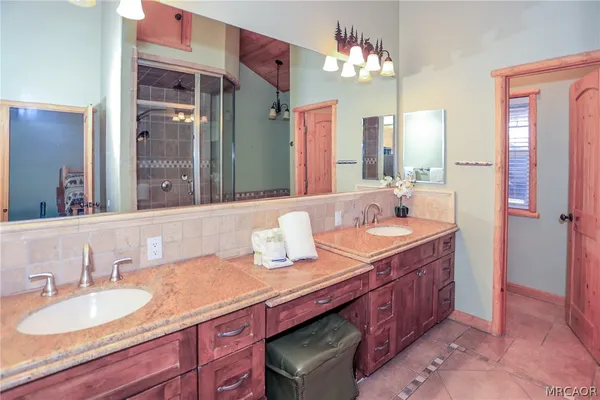 a bedroom with bed a chandelier and a flat screen tv