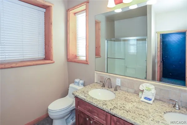 a living room with furniture a table and kitchen view