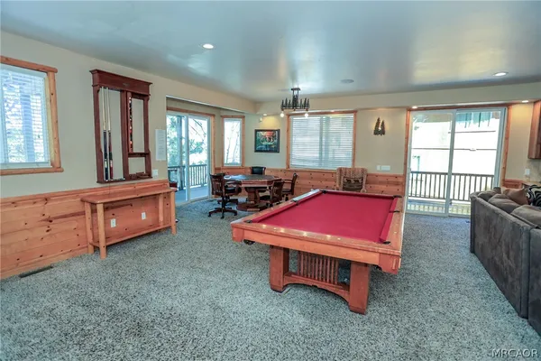 a living room with furniture pool table and flat screen tv