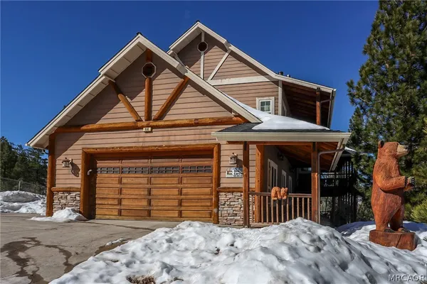 a view of a white house with a large tree