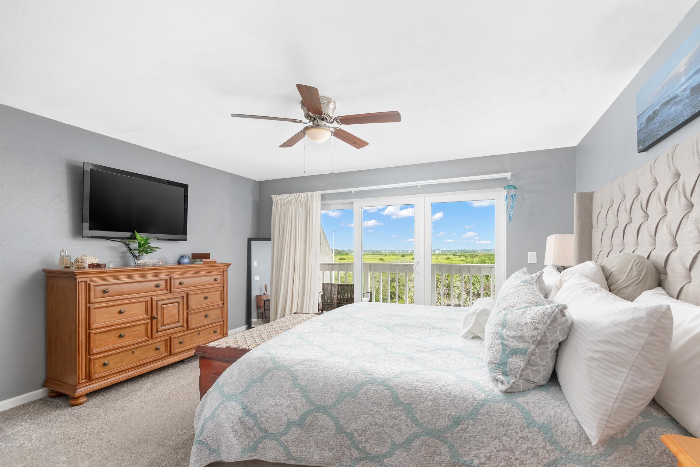 3385 Coastal Highway, Unit 22 St. Augustine, FL 32084 - Photo 25 of 35 a bedroom with a large bed and flat tv screen on dresser