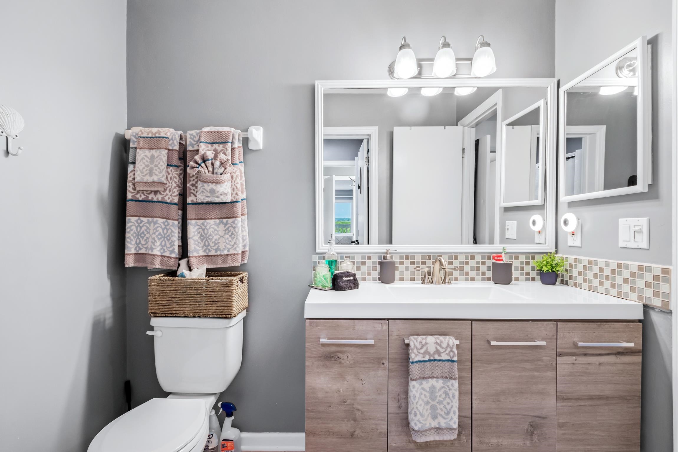 3385 Coastal Highway, Unit 22 St. Augustine, FL 32084 - Photo 26 of 35 a bathroom with a granite countertop toilet sink and mirror