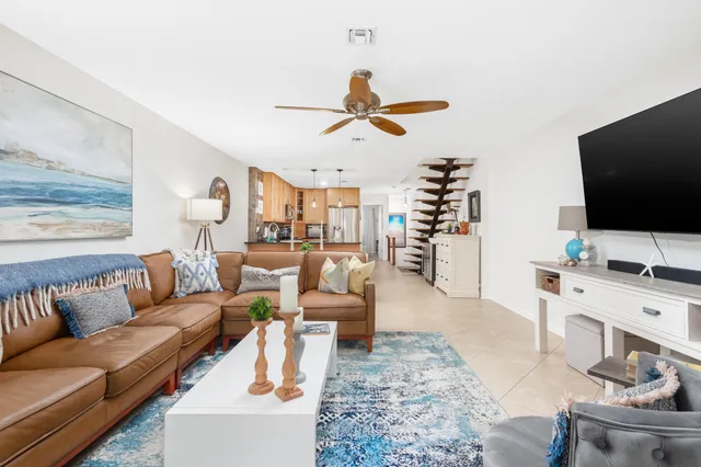 a living room with furniture a flat screen tv and a large window