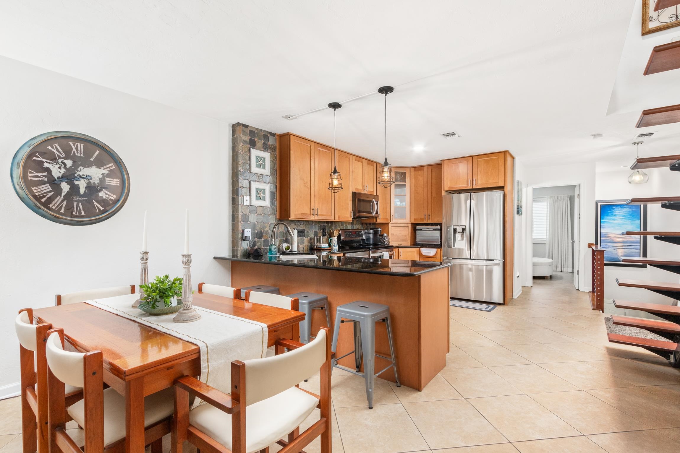 3385 Coastal Highway, Unit 22 St. Augustine, FL 32084 - Photo 10 of 35 a kitchen with stainless steel appliances kitchen island granite countertop a table chairs and a refrigerator
