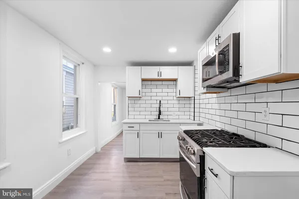 a kitchen with stainless steel appliances a stove a sink and a microwave
