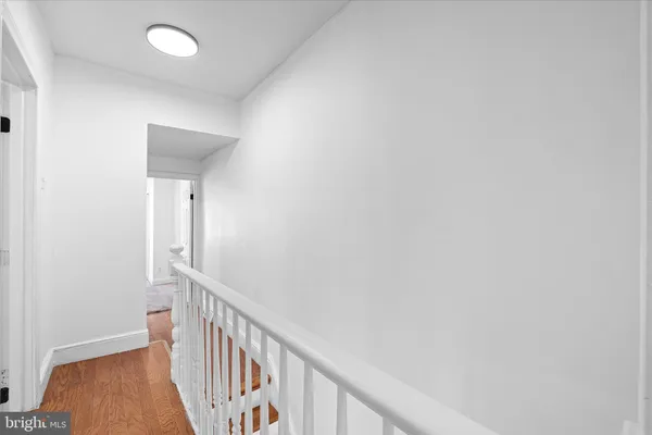 a view of a hallway with wooden floor and entryway