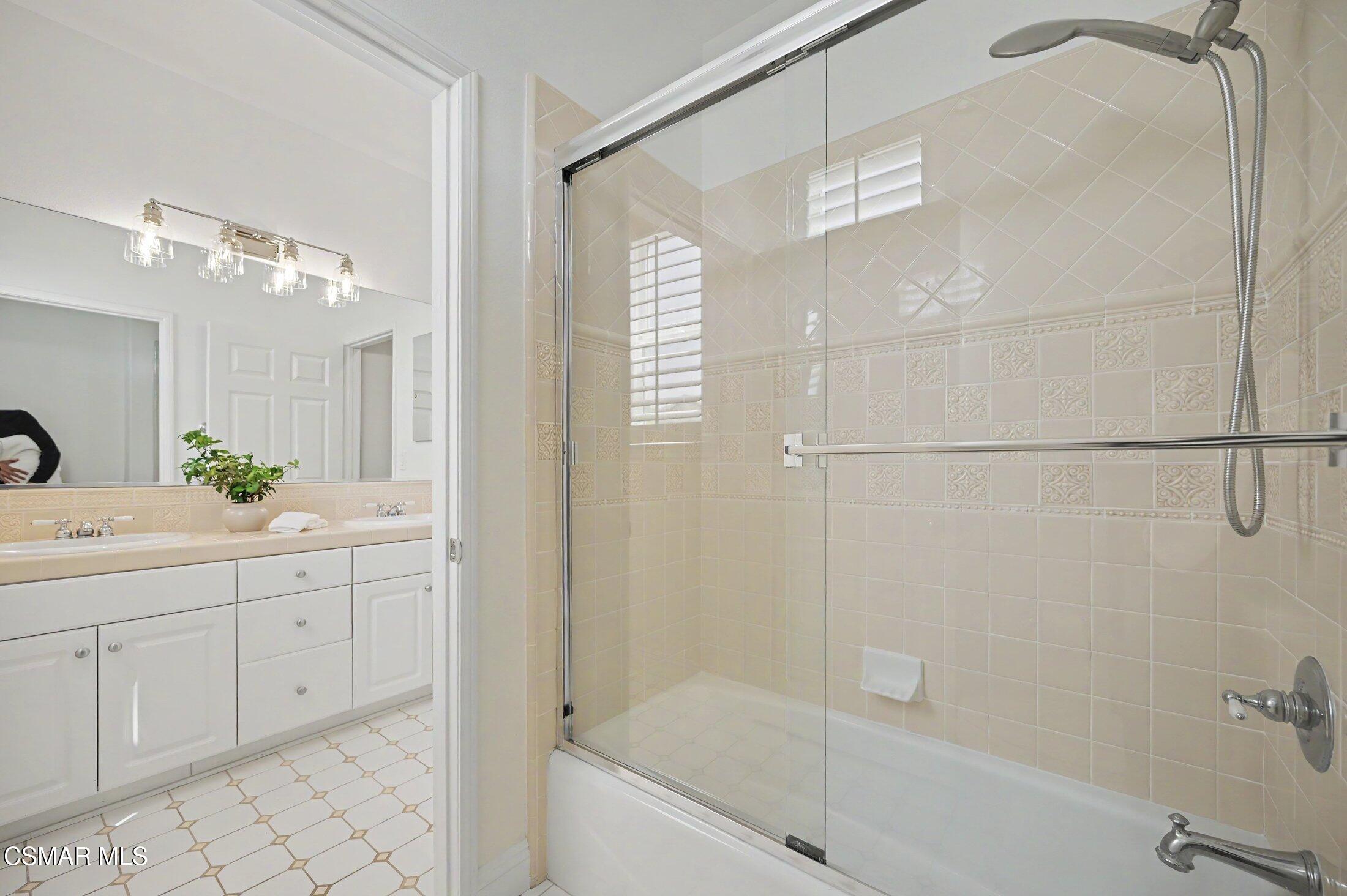 20800 Sardinia Way Porter Ranch, CA 91326 - Photo 40 of 57 a bathroom with a granite countertop sink a mirror and shower
