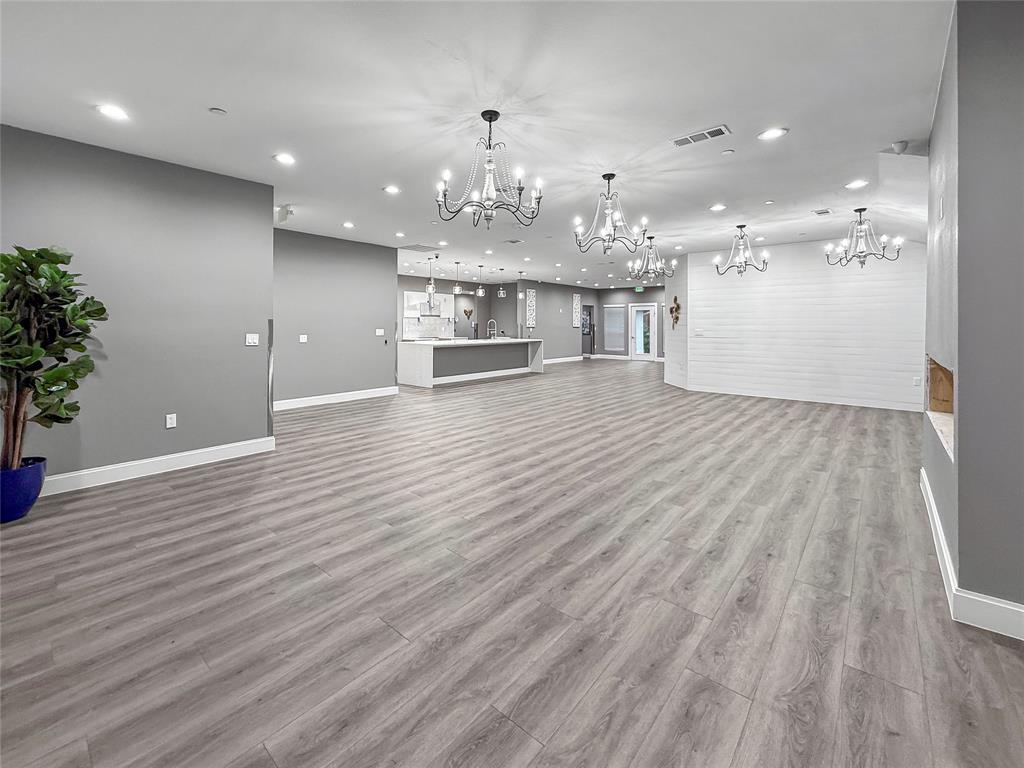 2402 Country Valley Road Garland, TX 75041 - Photo 13 of 39 a view of a big room with wooden floor and kitchen view