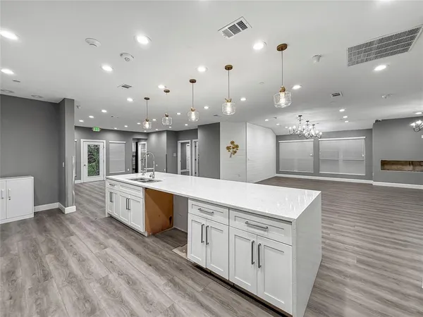a large white kitchen with lots of counter space a sink and appliances