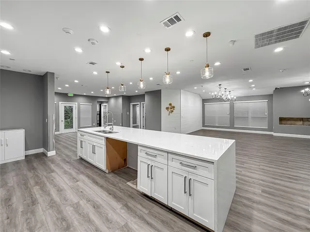 a large white kitchen with lots of counter space a sink and appliances