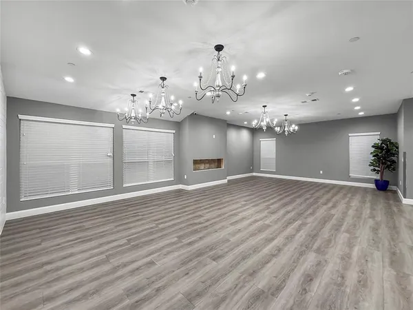 a view of a room with chandelier and wooden floor