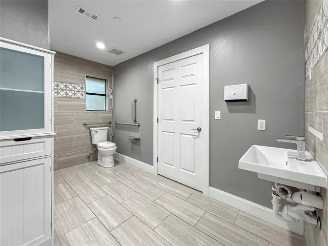 a bathroom with a sink a toilet and mirror