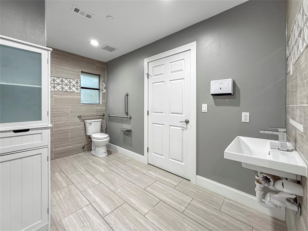 2402 Country Valley Road Garland, TX 75041 - Photo 19 of 39 a bathroom with a sink a toilet and mirror