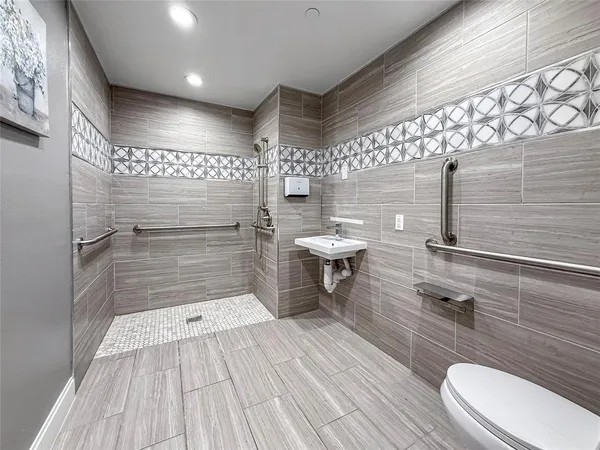 a bathroom with a sink a toilet and shower