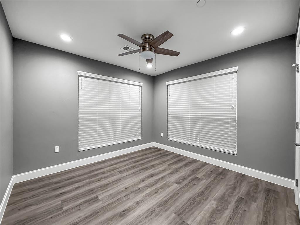 2402 Country Valley Road Garland, TX 75041 - Photo 24 of 39 a view of an empty room with wooden floor and a window