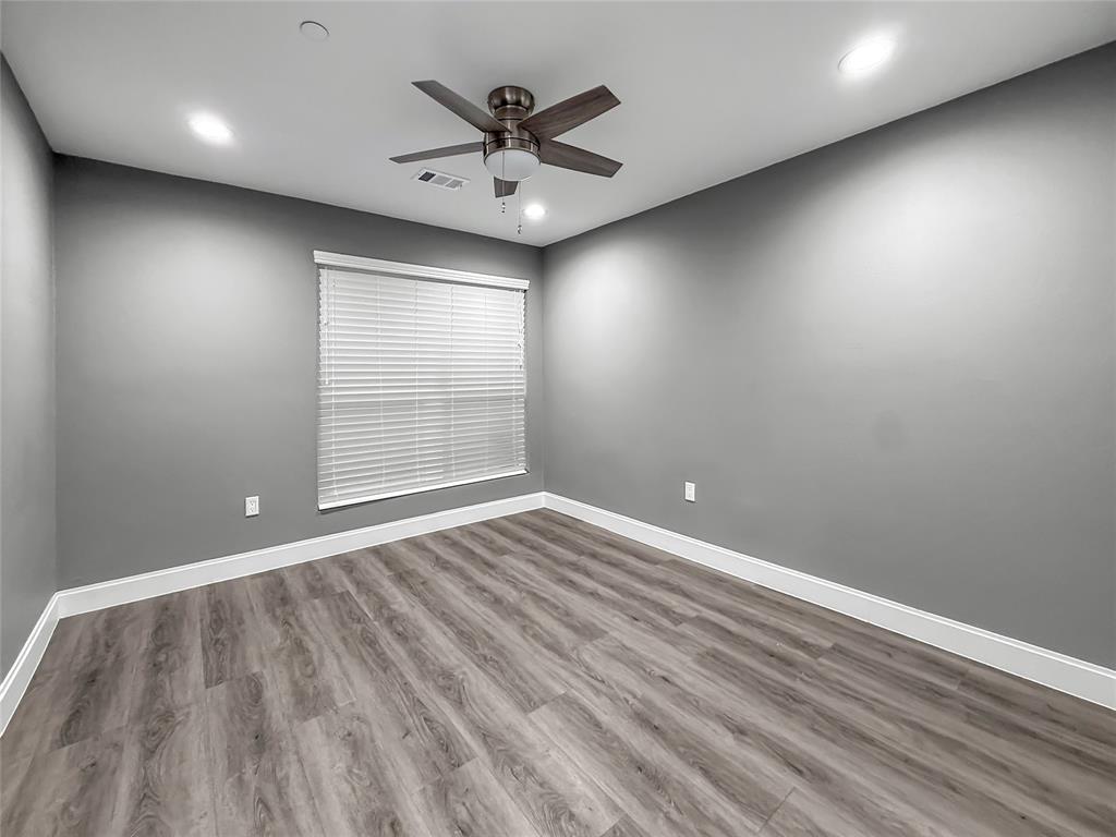 2402 Country Valley Road Garland, TX 75041 - Photo 31 of 39 an empty room with wooden floor and windows