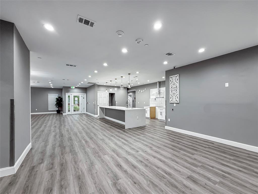 2402 Country Valley Road Garland, TX 75041 - Photo 10 of 39 a view of an empty room with wooden floor and kitchen