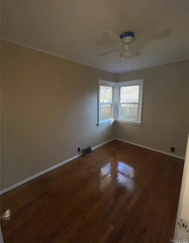 a view of a small house with a small yard and large tree