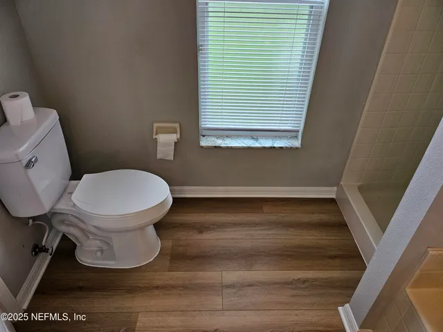 a bathroom with a toilet and a window