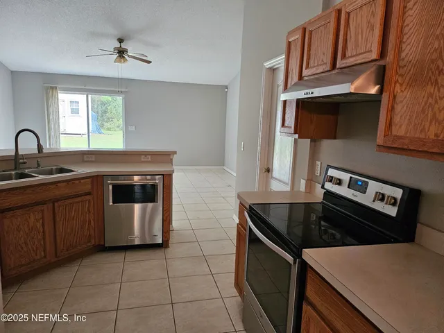 a kitchen with a stove sink and cabinets